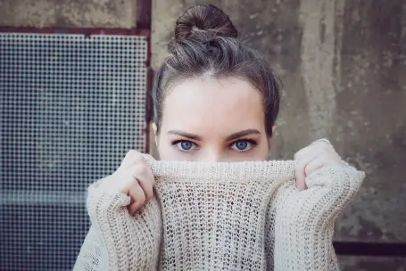A woman with a bun wearing a white sweater